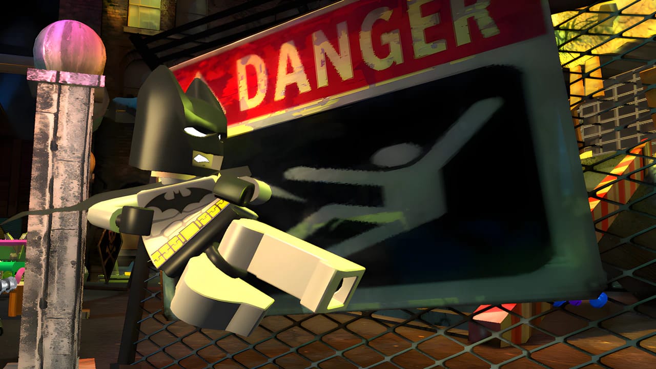 LEGO Batman 1 gameplay screenshot showing a hazard warning sign in a chemical plant level with retro graphics.