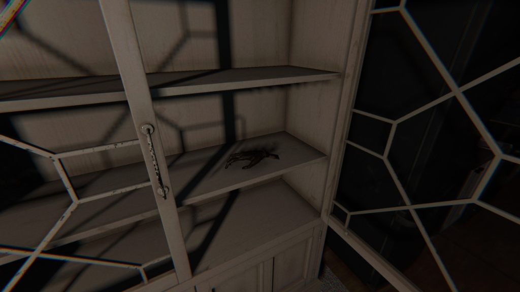 A cursed monkey's paw artifact resting inside a wooden cabinet.