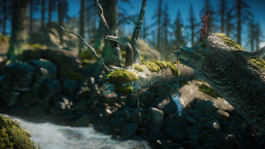Yarny and his blue counterpart hanging from a mossy log bridge.