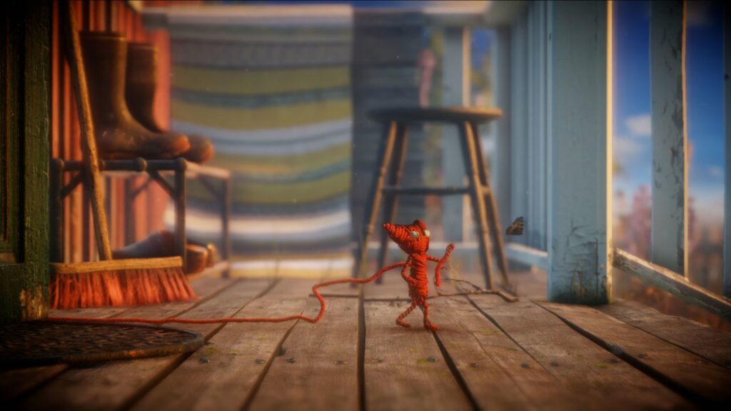 Yarny walking on a wooden porch in the game Unravel.